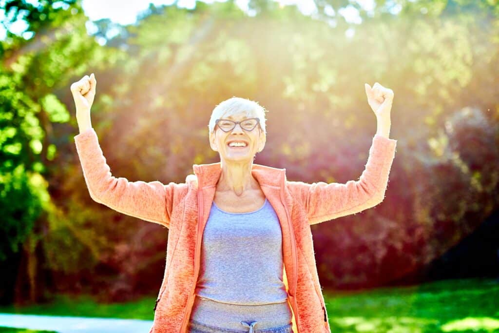 senior woman raising her arms