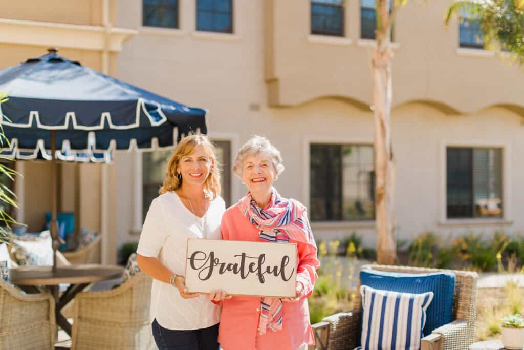 two ladies holding sign that says grateful