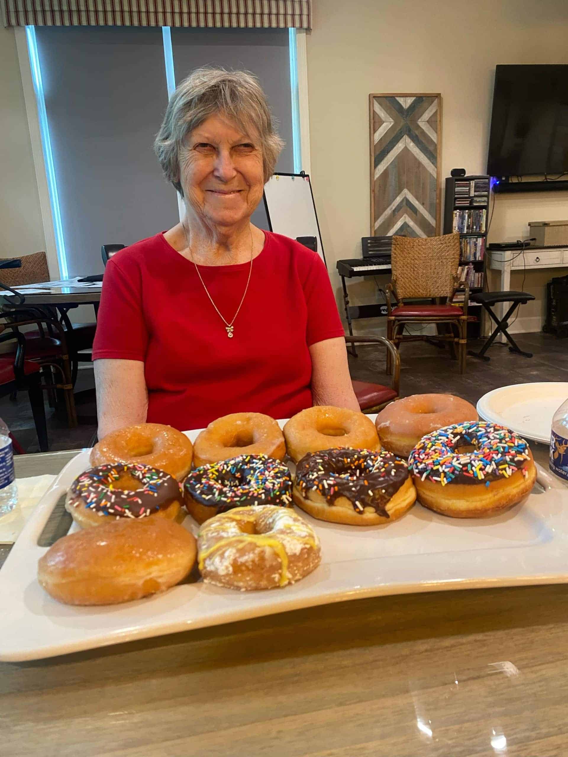 elderly resident with plate of donuts