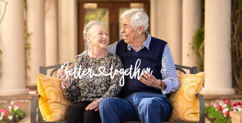 senior couple with sign that read better together